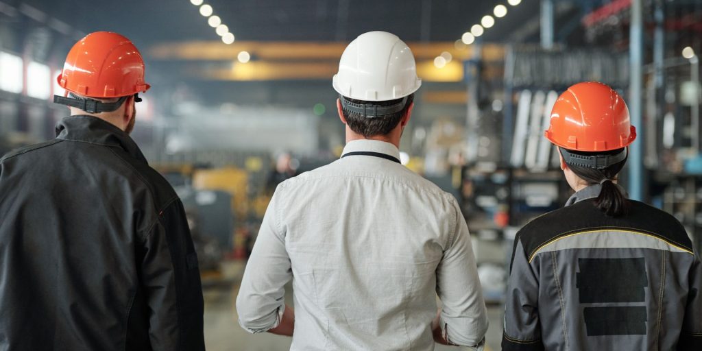 Three men walking in manufacturing site